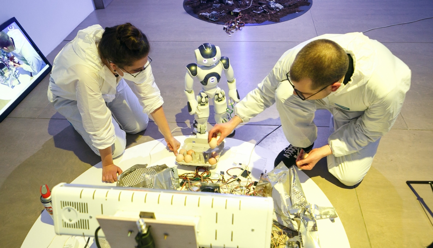 Robots NaoMi ar jaunajiem māksliniekiem Laimu Graždanoviču un Jurģi Peteru rezidencē “Kontakt/Ligzda”, RIXC galerijā. Foto: Juris Rozenbergs.